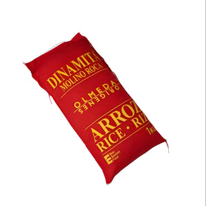 A red bag of Dinamillo Molino Roca Arroz Rice, 1kg package, shown diagonally on a solid black background.